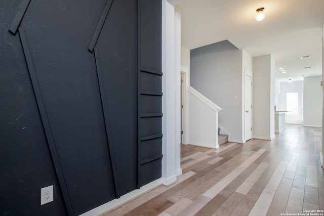 hallway with light hardwood / wood-style flooring