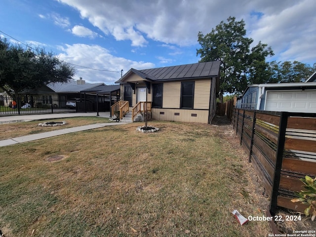 bungalow-style house with a standing seam roof, a front lawn, metal roof, fence, and crawl space