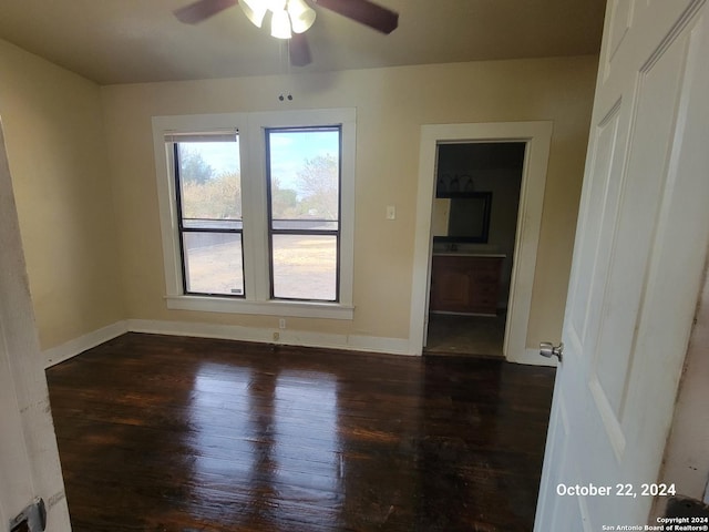 unfurnished room featuring wood-type flooring, a ceiling fan, and baseboards