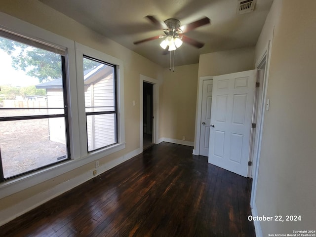 unfurnished room with dark wood-style floors, baseboards, a ceiling fan, and visible vents