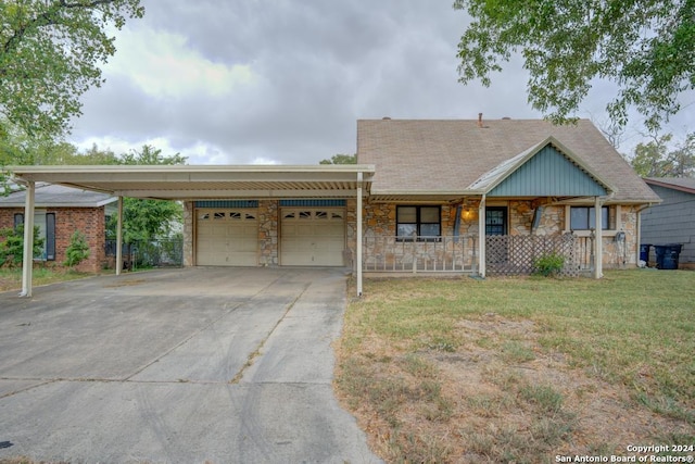 view of front of home with covered porch, a carport, a front lawn, and a garage