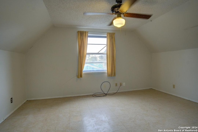 additional living space featuring lofted ceiling, a textured ceiling, and ceiling fan