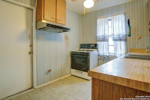 kitchen featuring sink, white stove, and ceiling fan