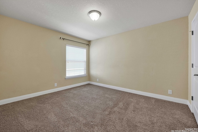 unfurnished room featuring carpet and a textured ceiling