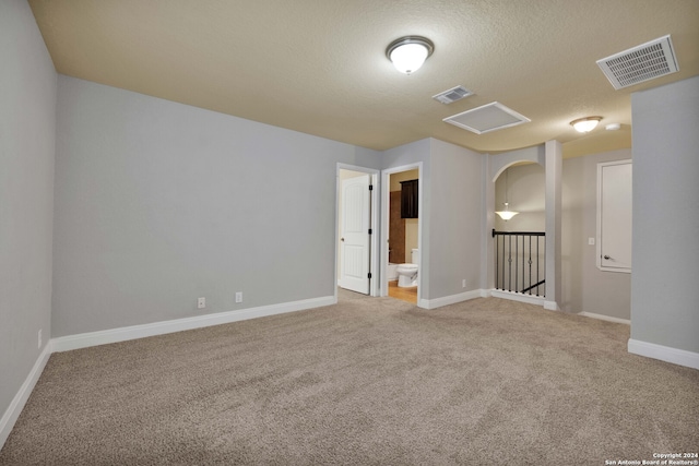 spare room featuring carpet and a textured ceiling