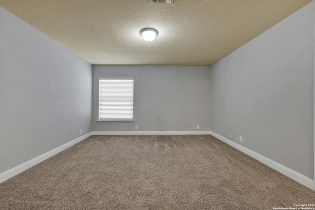 unfurnished room featuring carpet flooring and a textured ceiling