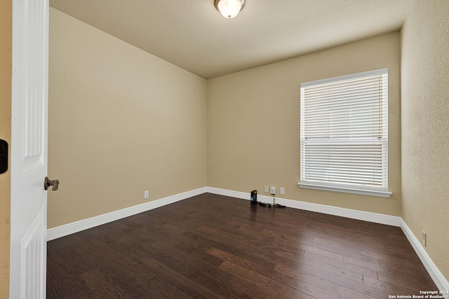 unfurnished room with dark hardwood / wood-style floors