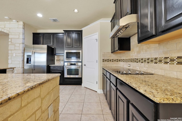 kitchen with range hood, light stone counters, appliances with stainless steel finishes, and backsplash