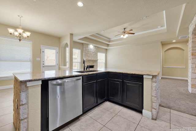 kitchen with sink, dishwasher, a fireplace, hanging light fixtures, and light carpet