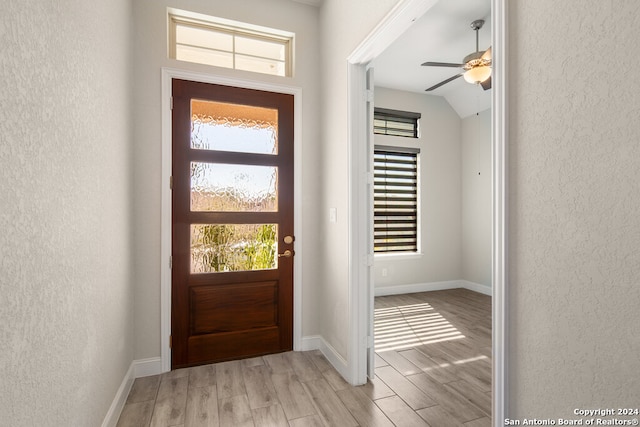 entryway with vaulted ceiling, light hardwood / wood-style flooring, and ceiling fan