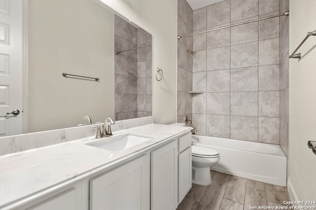 full bathroom featuring toilet, tiled shower / bath combo, hardwood / wood-style flooring, and vanity