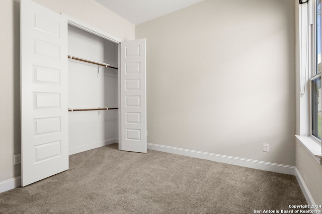 unfurnished bedroom featuring carpet flooring and a closet