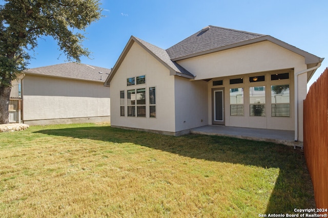 rear view of house featuring a patio area and a yard