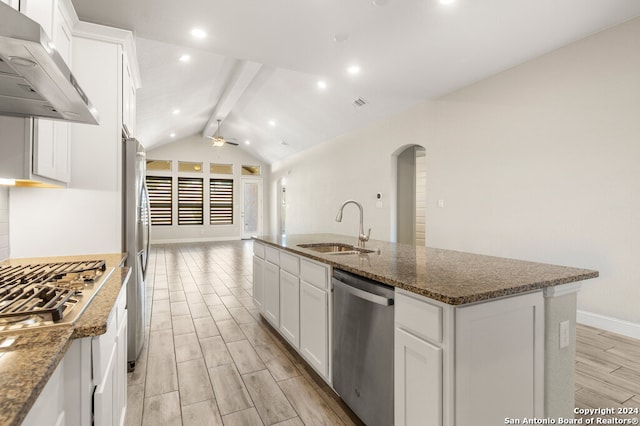 kitchen featuring lofted ceiling with beams, white cabinetry, stainless steel appliances, exhaust hood, and a center island with sink