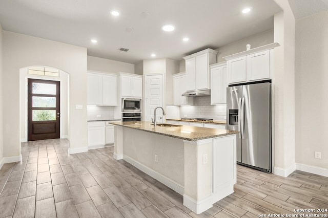 kitchen featuring light hardwood / wood-style flooring, stainless steel appliances, a center island with sink, sink, and white cabinets