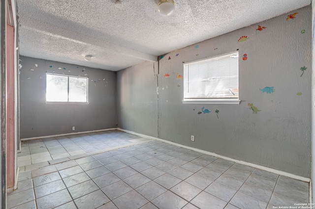 tiled spare room featuring a textured ceiling