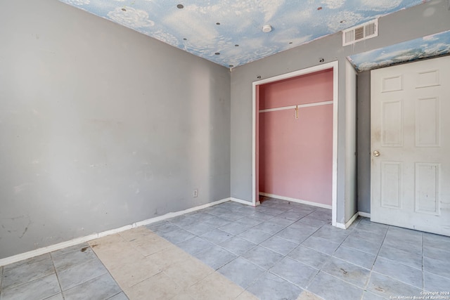 unfurnished bedroom featuring a closet and light tile patterned flooring