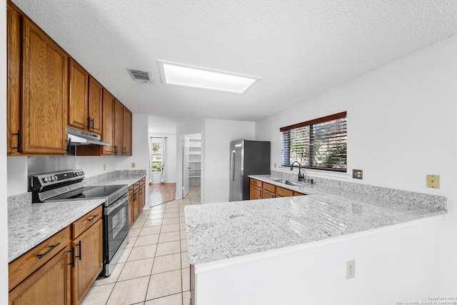 kitchen with a wealth of natural light, kitchen peninsula, appliances with stainless steel finishes, and sink