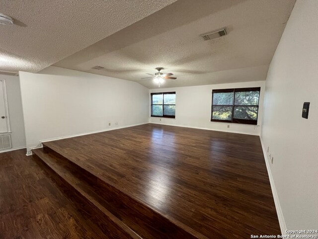 unfurnished room with dark hardwood / wood-style flooring, a textured ceiling, and ceiling fan