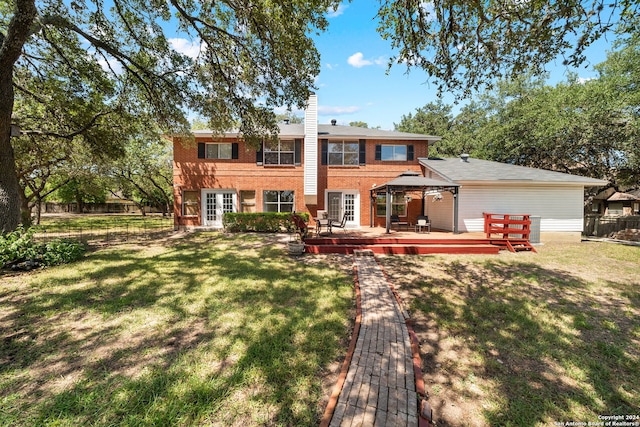 back of property featuring a lawn and a wooden deck