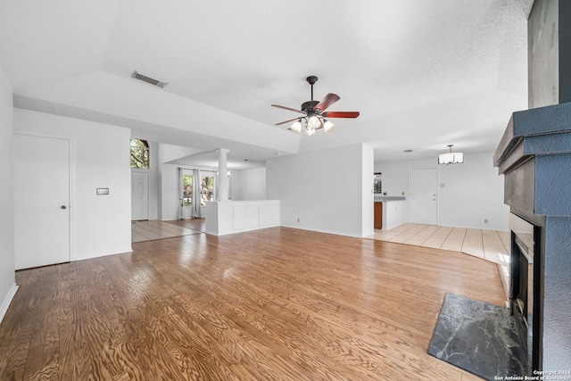 unfurnished living room featuring light wood-type flooring, a textured ceiling, and ceiling fan