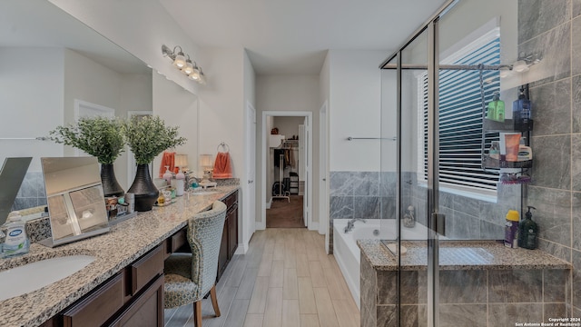 bathroom with vanity and shower with separate bathtub