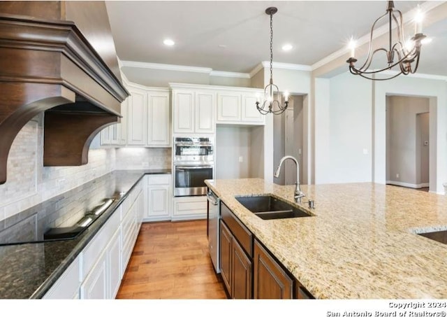 kitchen with sink, light hardwood / wood-style floors, stainless steel appliances, white cabinets, and light stone counters