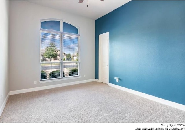 carpeted empty room featuring ceiling fan