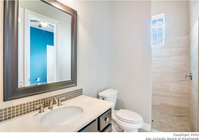 bathroom featuring toilet, vanity, and tiled shower