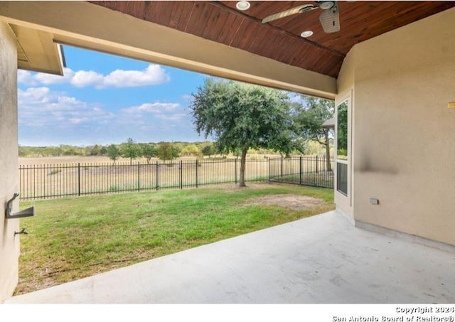 view of yard featuring a rural view, a patio area, and ceiling fan