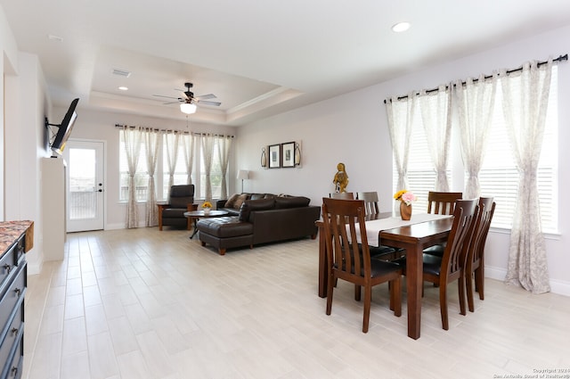 dining room with a raised ceiling and ceiling fan