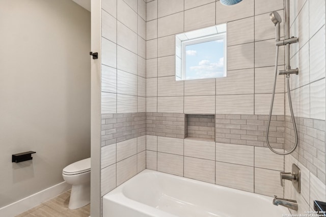 bathroom featuring toilet, tiled shower / bath, and hardwood / wood-style floors