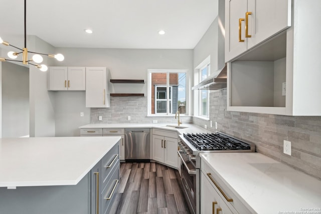 kitchen with dark hardwood / wood-style floors, white cabinets, stainless steel appliances, and pendant lighting