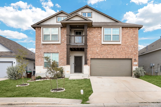 view of front facade with a balcony, a front lawn, and a garage