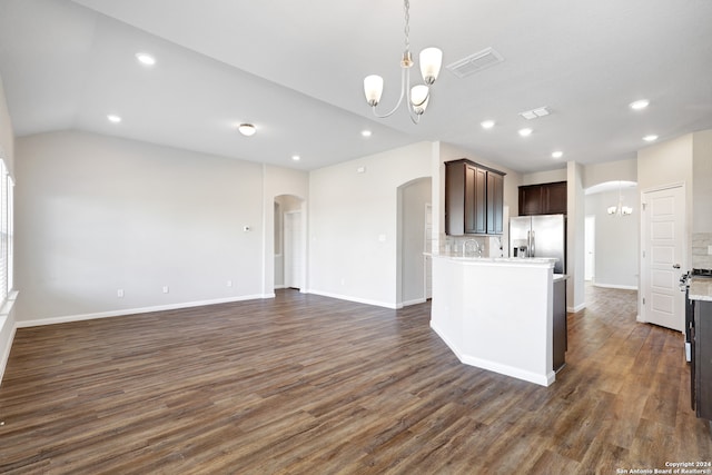 kitchen with stainless steel fridge, dark wood-type flooring, dark brown cabinets, and lofted ceiling