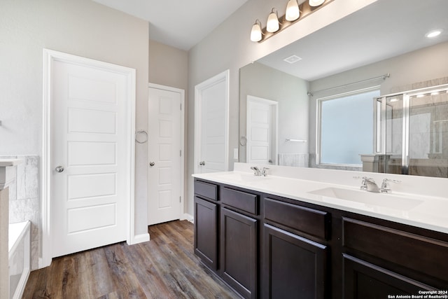 bathroom with vanity, hardwood / wood-style flooring, and plus walk in shower