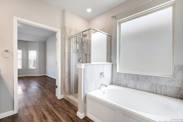 bathroom featuring wood-type flooring and separate shower and tub