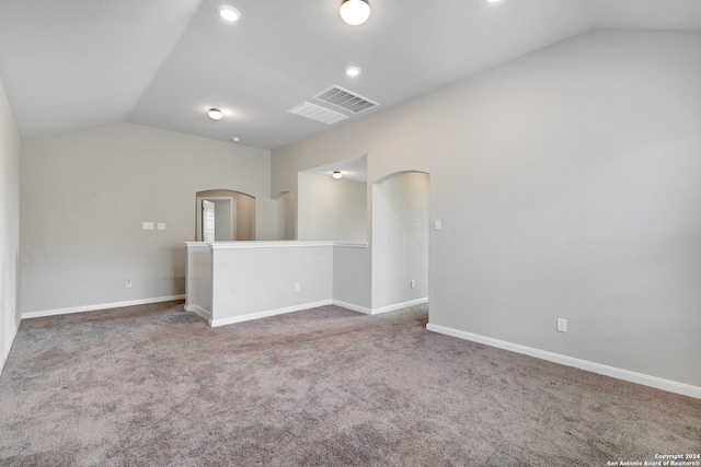 carpeted empty room with lofted ceiling