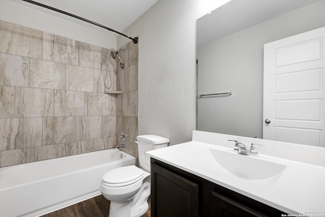 full bathroom featuring vanity, toilet, hardwood / wood-style flooring, and tiled shower / bath