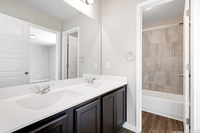 bathroom featuring vanity, tiled shower / bath combo, and wood-type flooring