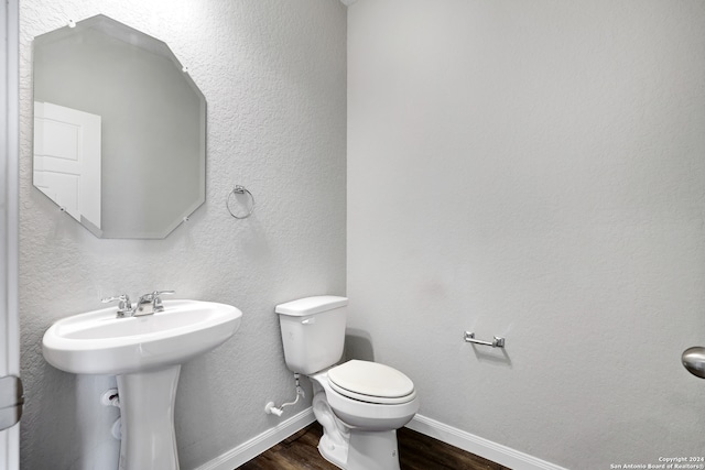 bathroom with toilet, sink, and wood-type flooring