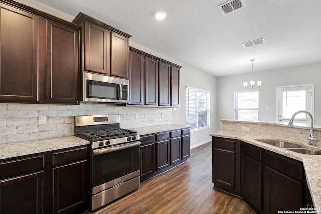 8116 Chasemont Ct, Converse, TX 78109 - kitchen with stainless steel appliances, a sink, tasteful backsplash, a chandelier, and dark wood-style floors