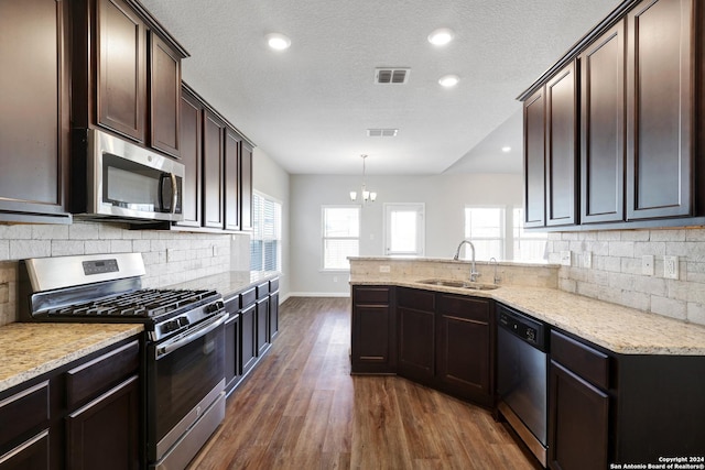 8116 Chasemont Ct, Converse, TX 78109 - kitchen featuring stainless steel appliances, a sink, dark wood finished floors, dark brown cabinets, and tasteful backsplash