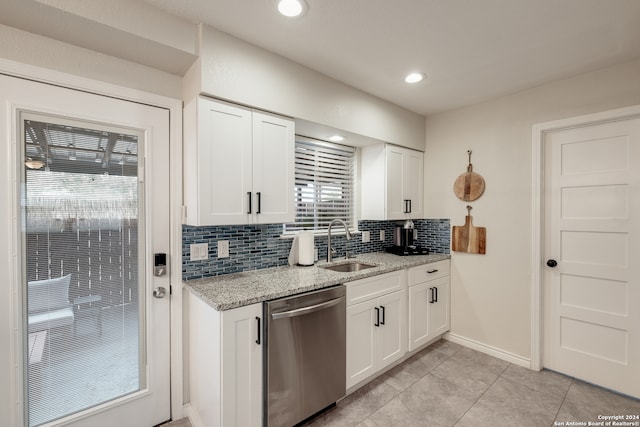 kitchen with sink, backsplash, stainless steel dishwasher, white cabinets, and light stone counters