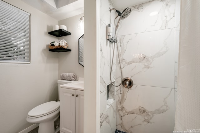 bathroom with vanity, a tile shower, and toilet