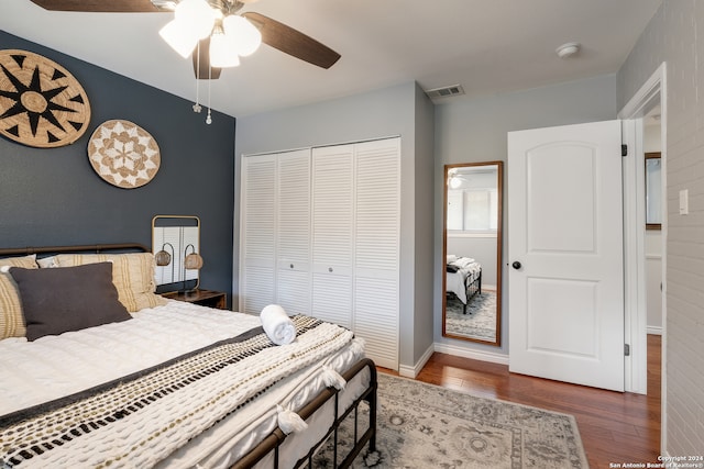 bedroom with a closet, dark wood-type flooring, and ceiling fan