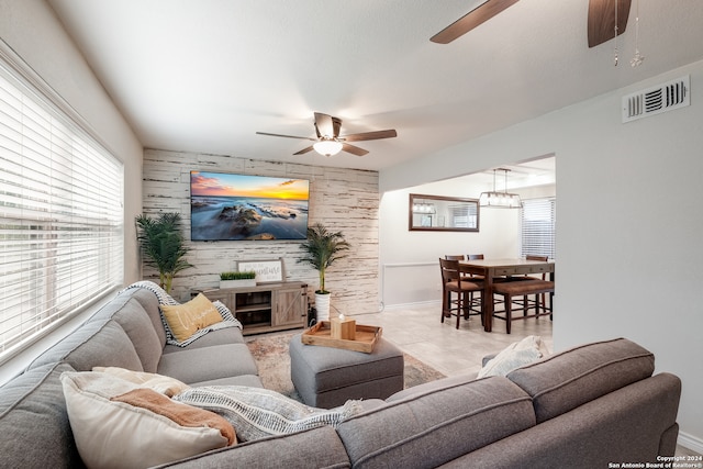 living room featuring light tile patterned floors, a fireplace, and ceiling fan