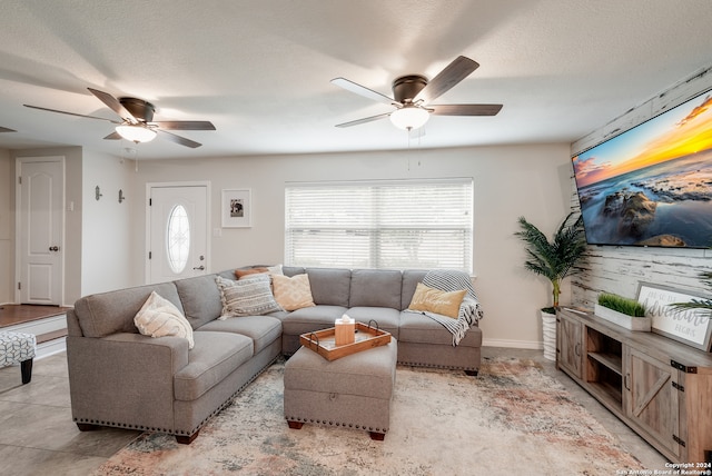 living room featuring ceiling fan and a textured ceiling