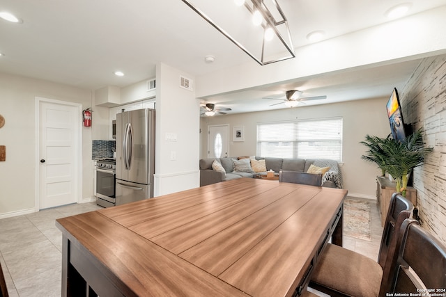 tiled dining space featuring ceiling fan