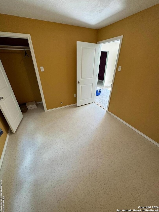 unfurnished bedroom featuring a closet and a textured ceiling